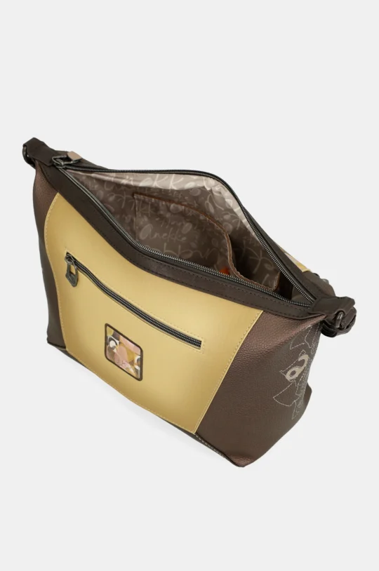Two-tone brown crossbody bag with a tan front panel, zipper open to reveal patterned beige interior lining and pocket detail inside