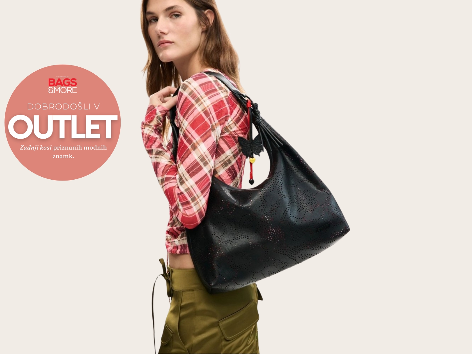 Model wearing a red plaid shirt carries a large black perforated tote against a beige backdrop, with a pink circular OUTLET graphic on the left.